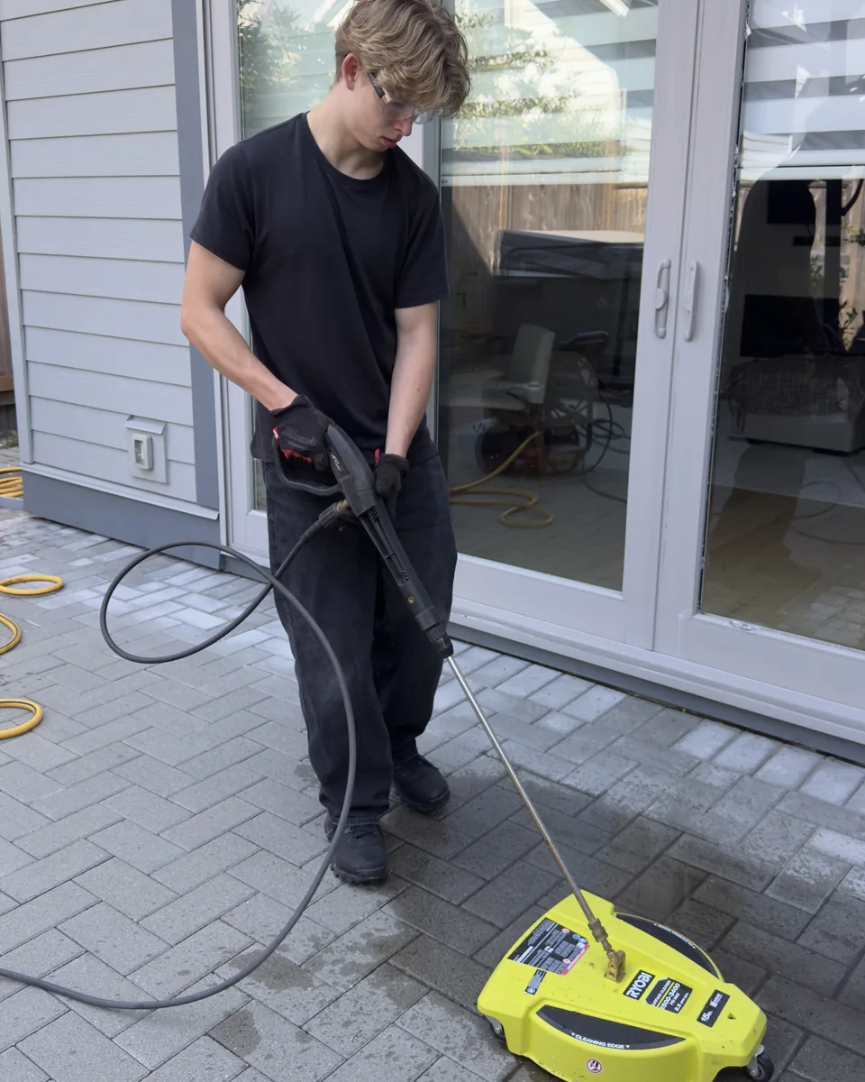 West Wave Wash field technician cleaning a paver patio with a surface cleaner