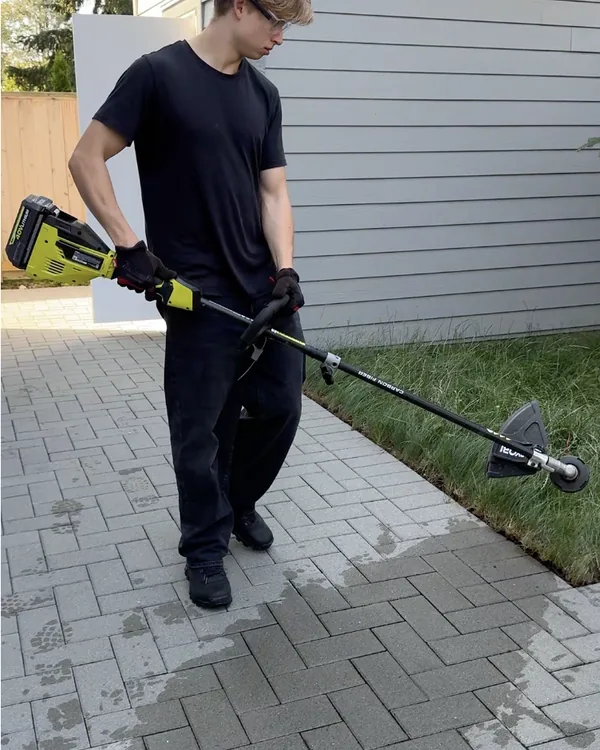 Edge cleanup beside an interlocking paver walkway